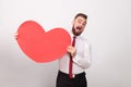 Funny businessman toothy smiling, holding big red heart