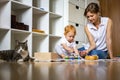 Funny cat relaxing mother and little toddler playing together self study of child Montessori method Royalty Free Stock Photo