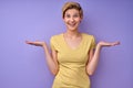 Funny caucasian female spreading arms don't know expression, isolated on purple