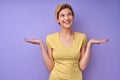 Funny caucasian female spreading arms don't know expression, isolated on purple