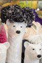 Funny ceramic polar bear Christmas decorations in a display with other items blurred behind them