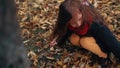 Funny, cheerful cute little girl close-up collects yellow autumn leaves in park slow motion