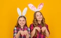 funny cheerful easter children in bunny ears on yellow background