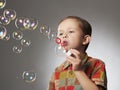 Funny child blowing soap bubbles. little boy