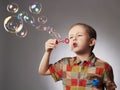 Funny child blowing soap bubbles. little boy