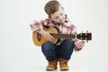 Funny child boy with guitar. country boy playing music