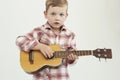 Funny child boy with guitar.fashionable country boy playing music