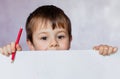 Funny child boy looks for a drawing album. Little boy is holding color pencils Royalty Free Stock Photo