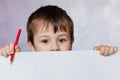 Funny child boy looks for a drawing album. Little boy is holding color pencils Royalty Free Stock Photo