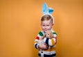 Funny child in bunny ears playing with rabbit. Little blond kid on Easter celebration. Egg hunt with pet animal Royalty Free Stock Photo