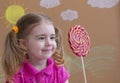 Funny child with candy lollipop, happy little girl eating big sugar lollipop, kid eat sweets. Beautiful little girl with Royalty Free Stock Photo