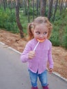 Funny child with candy lollipop, happy little girl eating big sugar lollipop, kid eat sweets. surprised child with candy Royalty Free Stock Photo