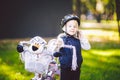 Funny child Caucasian girl blonde in a bicycle helmet near a purple bike with a basket in outside the park on a green Royalty Free Stock Photo