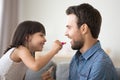 Funny child daughter applying lipstick on dads lips doing makeup Royalty Free Stock Photo