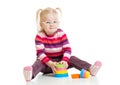 Funny child in eyeglases playing colorful pyramid