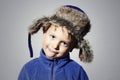 Funny child in fur Hat.little boy in blue sport sweater.children emotion Royalty Free Stock Photo