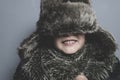 Funny child with fur hat and winter coat, cold concept and storm Royalty Free Stock Photo