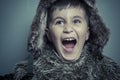 Funny child with fur hat and winter coat, cold concept and storm Royalty Free Stock Photo