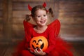 Funny child girl in devil halloween costume on dark wooden back Royalty Free Stock Photo