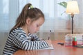 a funny child girl doing homework writing and reading at home Royalty Free Stock Photo