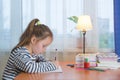 A funny child girl doing homework writing and reading at home Royalty Free Stock Photo