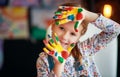 Funny child girl draws laughing shows hands dirty with paint Royalty Free Stock Photo