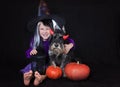 Funny child girl dressed witch costume with pumpkin. Halloween holidays concept.