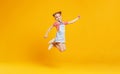 Funny child girl jumping on colored yellow background