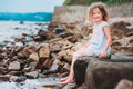 Funny child girl playing with water splash on the beach. Traveling on summer vacation. Royalty Free Stock Photo