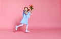 Funny child girl runs and jumps with bouquet of flowers on color Royalty Free Stock Photo