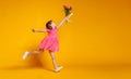 Funny child girl runs and jumps with bouquet of flowers on color Royalty Free Stock Photo