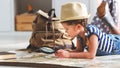 Funny child girl tourist with world map, backpack and magnifier Royalty Free Stock Photo