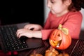 Funny child girl using a digital tablet laptop notebook. Online call friends or parents. Halloween concept Royalty Free Stock Photo