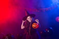 Funny child girl in witch costume for Halloween with pumpkin Jack. Royalty Free Stock Photo