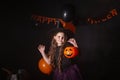 Funny child girl in witch costume for Halloween with pumpkin Jack. Royalty Free Stock Photo