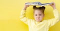 Funny child girl yellow jacket on a yellow background, sitting, reading a book, development and school concept Royalty Free Stock Photo