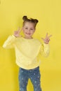 Back to school, funny child girl yellow jacket on a yellow background, sitting, reading a book, development and school Royalty Free Stock Photo