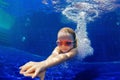 Funny child in goggles dive in swimming pool