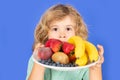 Funny child hold plate with fruits. Funny child eating fresh fruit. Child eating fresh fruit. Kid with fruits and