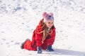 Funny child playing with snow in winter. Little girl in colorful jacket and knitted. Kids play in snowy forest. Children