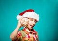 Funny child Santa holding a big sea shell smiling. Winter holidays concept.