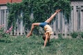 Funny child teenage girl doing cartwheel on a backyard. Excited joyful kid playing outdoor. Happy lifestyle childhood and freedom Royalty Free Stock Photo