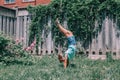 Funny child teenage girl doing cartwheel upside down stand. Excited joyful kid playing outdoors. Happy lifestyle childhood and Royalty Free Stock Photo