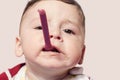 Funny child trying to feed himself baby food holding the spoon in the mouth. Royalty Free Stock Photo