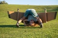 Funny child upside down on grass with toy jetpack. Child pilot astronaut or spaceman dreams of flight. Aviator boy