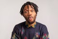 Funny childish african man with dreadlocks and beard making fish face, having fun, kidding, pretending to be stupid Royalty Free Stock Photo