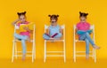 Funny children girls read books on colored yellow background