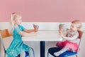 Funny children girls sitting together bragging boasting their ice-cream