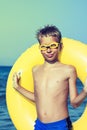 Funny chilld with swimmer goggles standing on beach Royalty Free Stock Photo