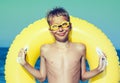 Funny chilld with swimmer goggles standing on beach Royalty Free Stock Photo